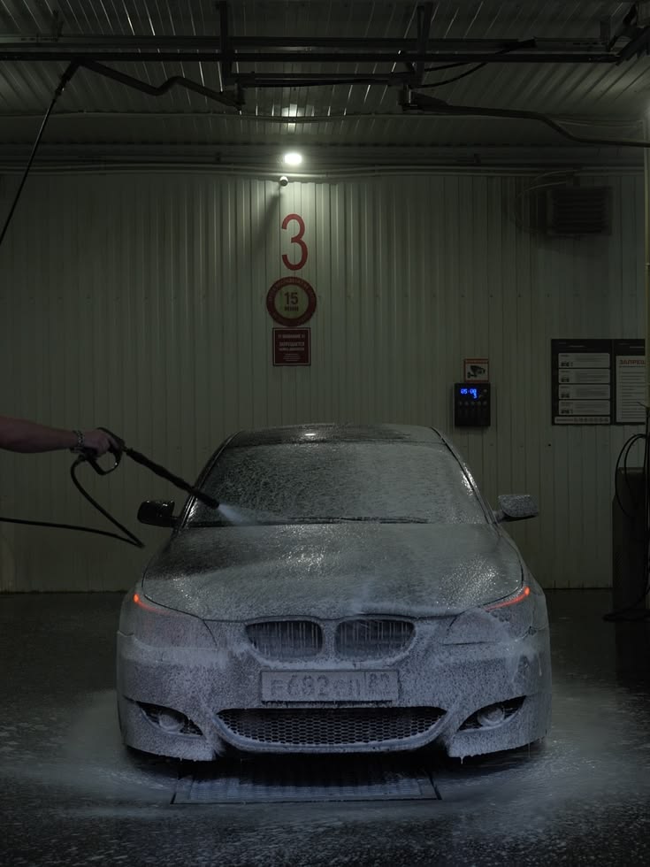 Car covered in foam in a wash bay